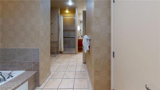 bathroom with plus walk in shower, tile patterned flooring, and tile walls