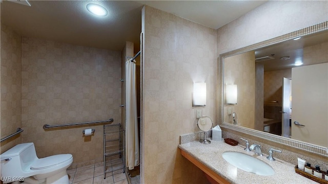 bathroom with tile patterned floors, toilet, tile walls, vanity, and curtained shower