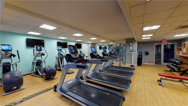 exercise room with wood-type flooring and a paneled ceiling