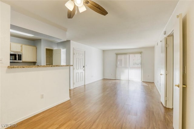 unfurnished living room featuring ceiling fan and light hardwood / wood-style floors