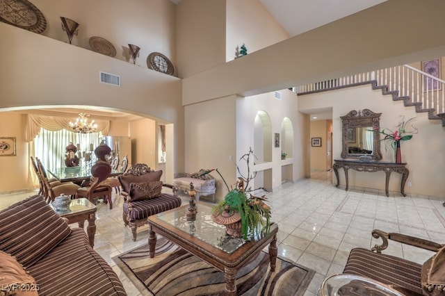 tiled living room with a chandelier and a high ceiling