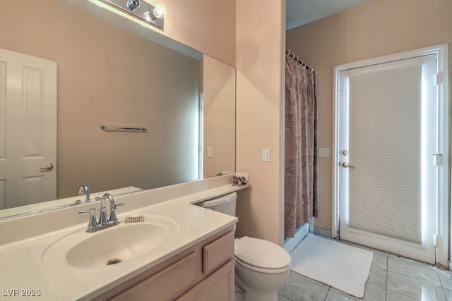 bathroom with tile patterned flooring, vanity, and toilet