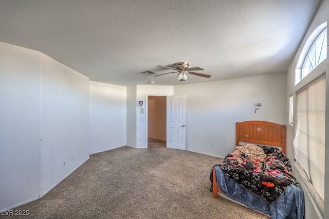 carpeted bedroom with ceiling fan and a textured ceiling