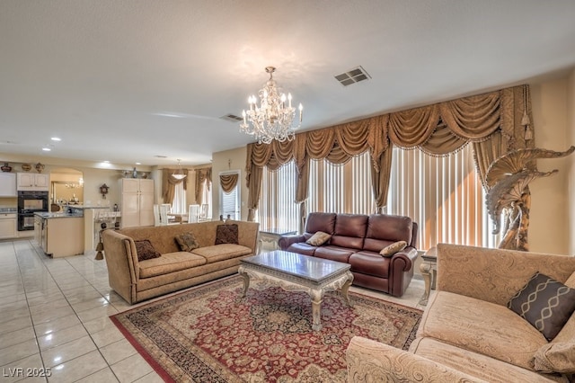 tiled living room with a notable chandelier