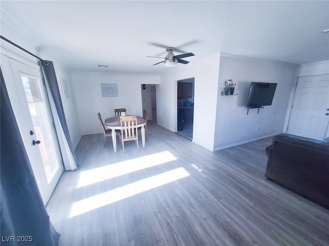 interior space featuring dark wood-type flooring, ceiling fan, and ornamental molding