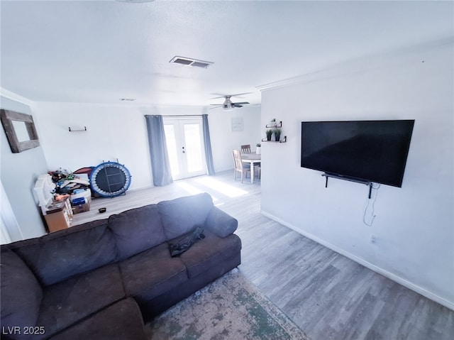 living room featuring hardwood / wood-style floors, french doors, and ceiling fan