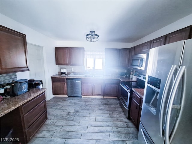 kitchen with tasteful backsplash, sink, stainless steel appliances, and dark brown cabinetry