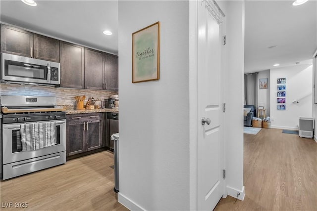 kitchen featuring stainless steel appliances, dark brown cabinets, backsplash, and light hardwood / wood-style flooring