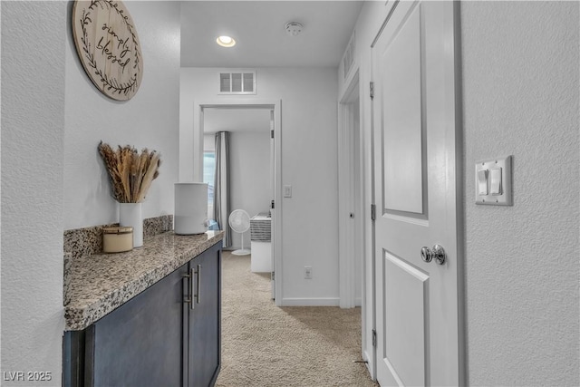 hallway featuring light colored carpet