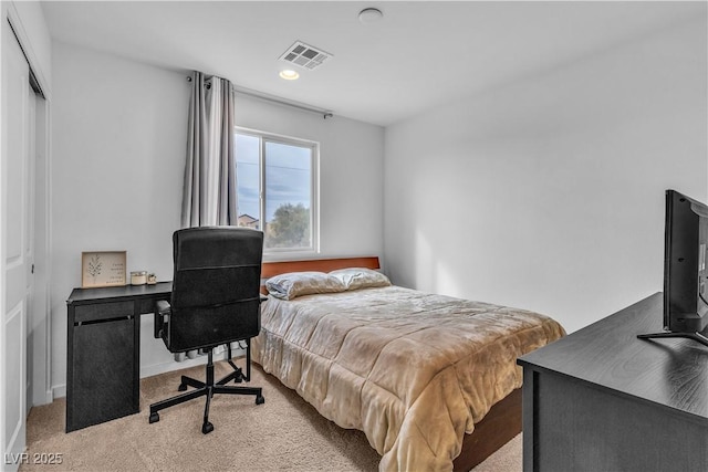 bedroom featuring light colored carpet and a closet