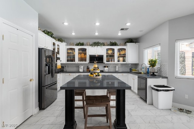 kitchen featuring white cabinets, sink, decorative backsplash, and black appliances