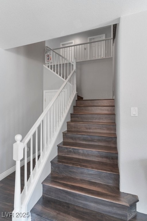 stairway with hardwood / wood-style flooring and a textured ceiling