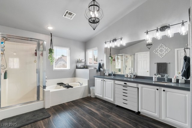 bathroom with vanity, hardwood / wood-style floors, vaulted ceiling, and independent shower and bath