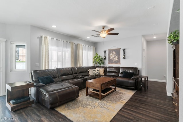 living room featuring dark wood-type flooring and ceiling fan