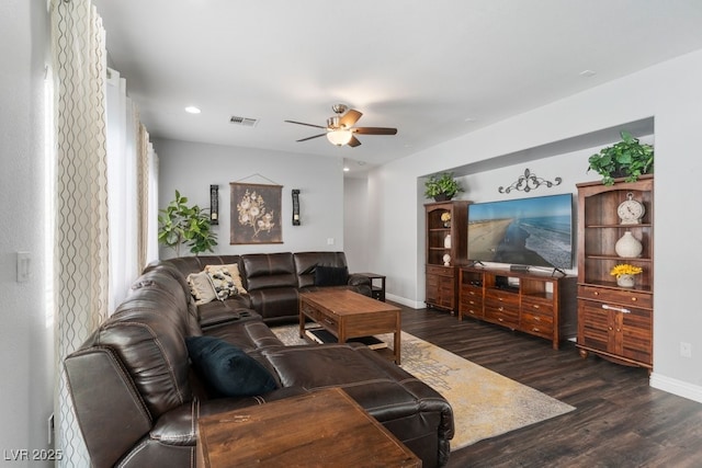 living room with dark wood-type flooring and ceiling fan