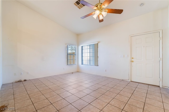 spare room featuring lofted ceiling, light tile patterned floors, and ceiling fan