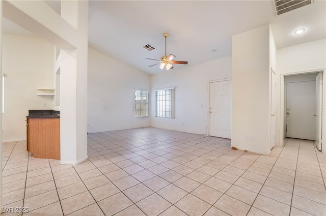 unfurnished living room featuring vaulted ceiling, light tile patterned floors, and ceiling fan