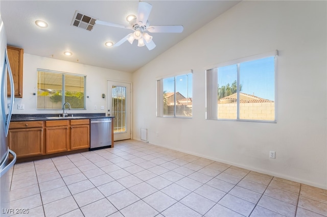 kitchen featuring sink, light tile patterned floors, dishwasher, ceiling fan, and vaulted ceiling