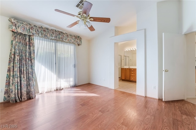 empty room with lofted ceiling, light hardwood / wood-style flooring, and ceiling fan