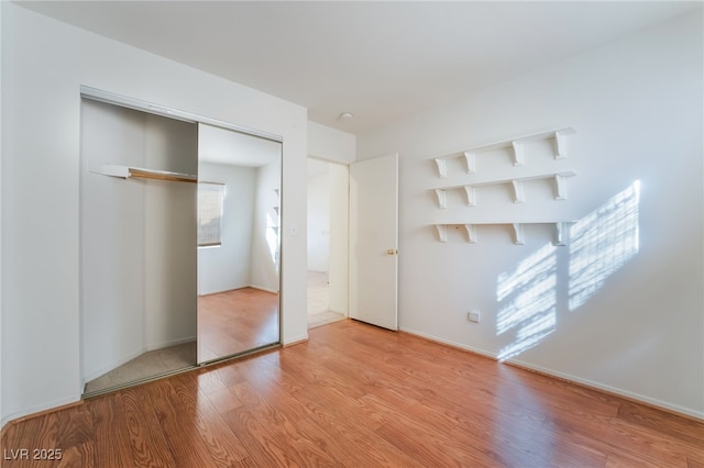 unfurnished bedroom featuring light wood-type flooring and a closet