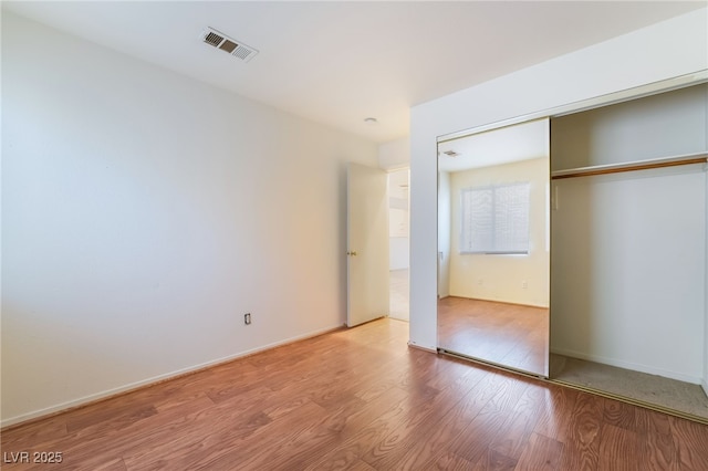 unfurnished bedroom featuring a closet and light hardwood / wood-style flooring