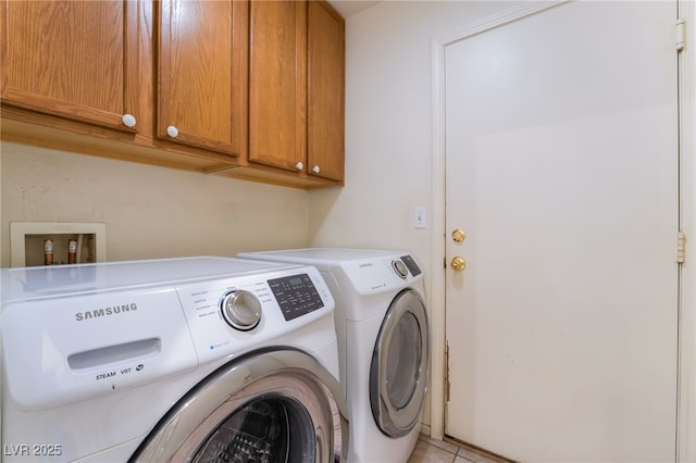 laundry area with cabinets, light tile patterned flooring, and washer and clothes dryer