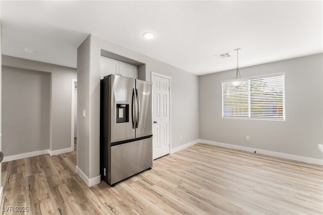 kitchen featuring stainless steel fridge with ice dispenser, light hardwood / wood-style floors, hanging light fixtures, and white cabinets