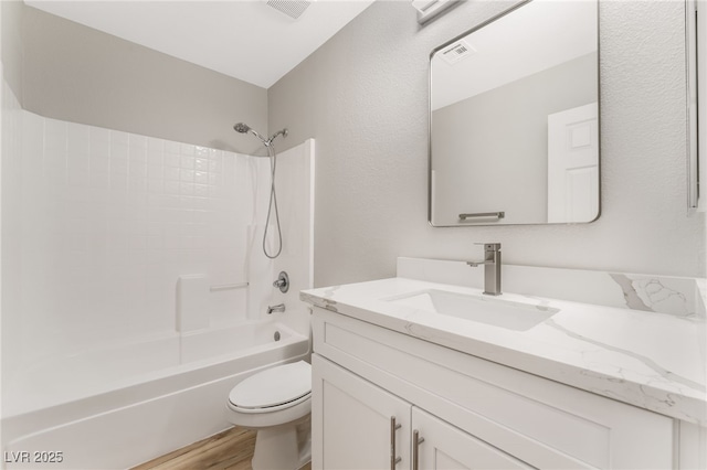 full bathroom featuring hardwood / wood-style flooring, vanity, shower / bathtub combination, and toilet