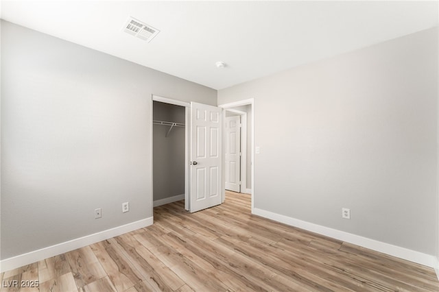 unfurnished bedroom featuring light hardwood / wood-style floors and a closet