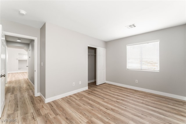 unfurnished bedroom with a closet and light wood-type flooring