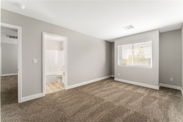 unfurnished bedroom featuring ensuite bath and carpet