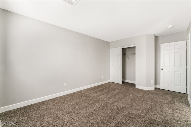 unfurnished bedroom with dark carpet and a closet