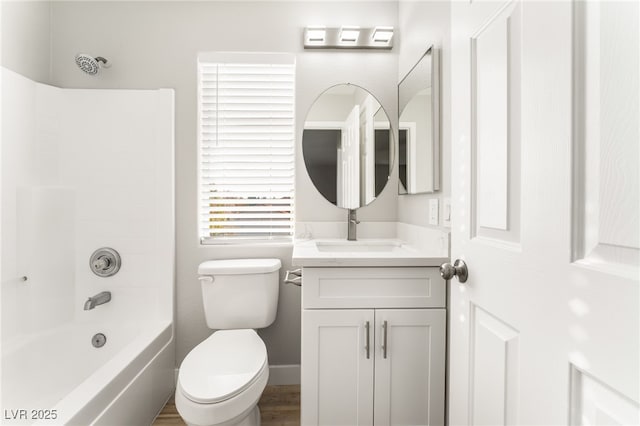 full bathroom with hardwood / wood-style flooring, vanity, tub / shower combination, and toilet