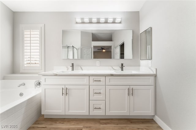 bathroom featuring hardwood / wood-style flooring, ceiling fan, vanity, and plus walk in shower