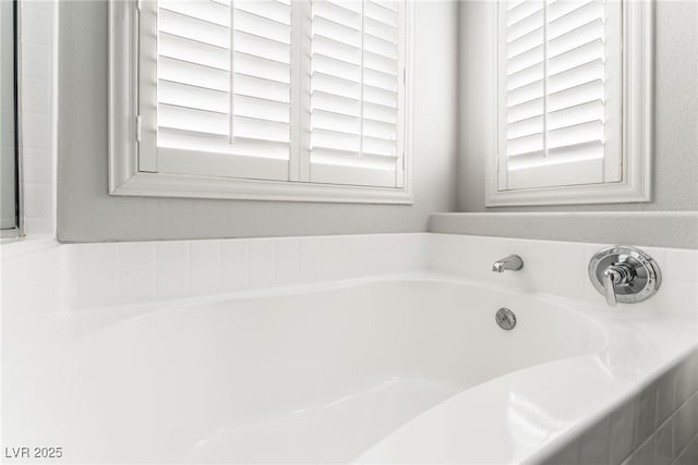 bathroom featuring a relaxing tiled tub