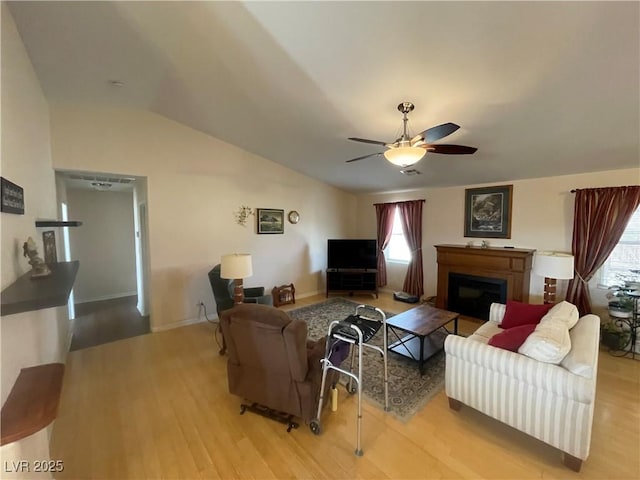 living room with ceiling fan, lofted ceiling, and light hardwood / wood-style floors