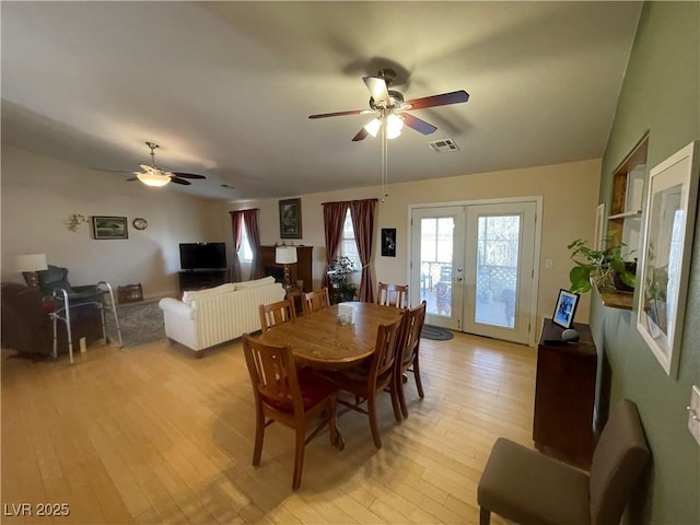 dining room with ceiling fan, light wood-type flooring, and french doors