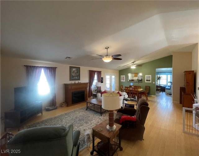 living room with french doors, ceiling fan, vaulted ceiling, and light hardwood / wood-style flooring