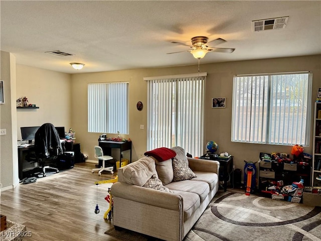 living room with ceiling fan and light wood-type flooring