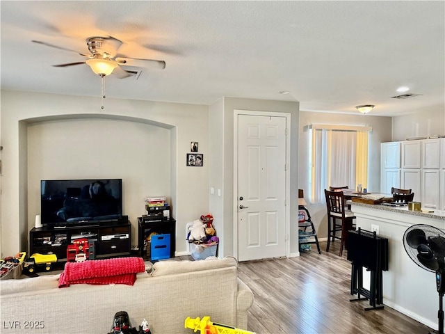 living room featuring ceiling fan and hardwood / wood-style floors