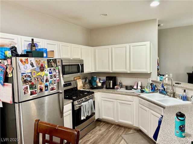 kitchen with white cabinetry, sink, light hardwood / wood-style flooring, and stainless steel appliances