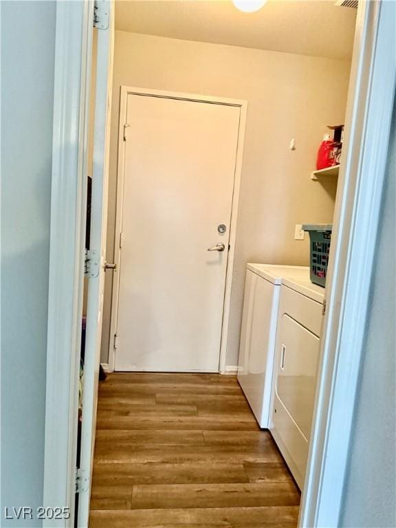 laundry area with light hardwood / wood-style floors and washer and dryer