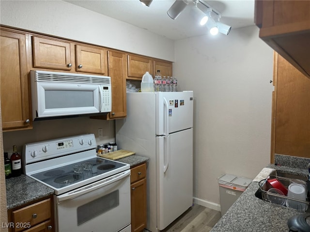 kitchen featuring ceiling fan, white appliances, track lighting, and light hardwood / wood-style flooring