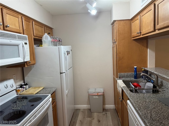 kitchen with sink, white appliances, and light wood-type flooring