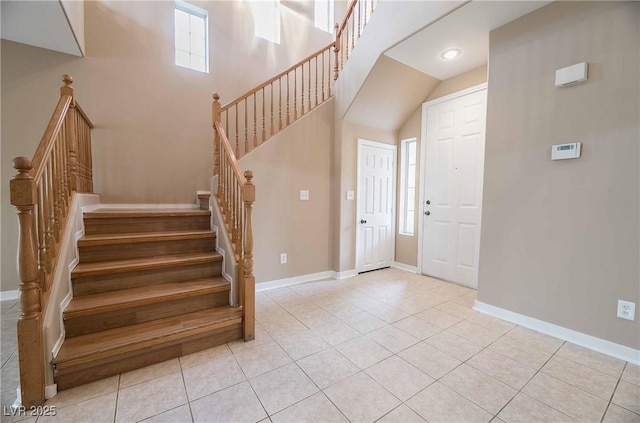 tiled foyer with a wealth of natural light and a high ceiling