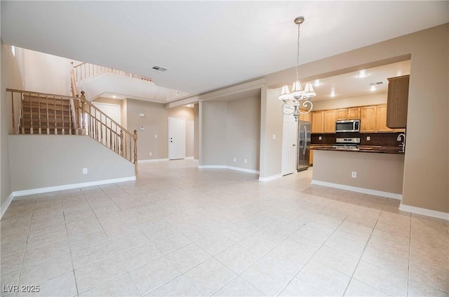 unfurnished living room with a notable chandelier and light tile patterned floors