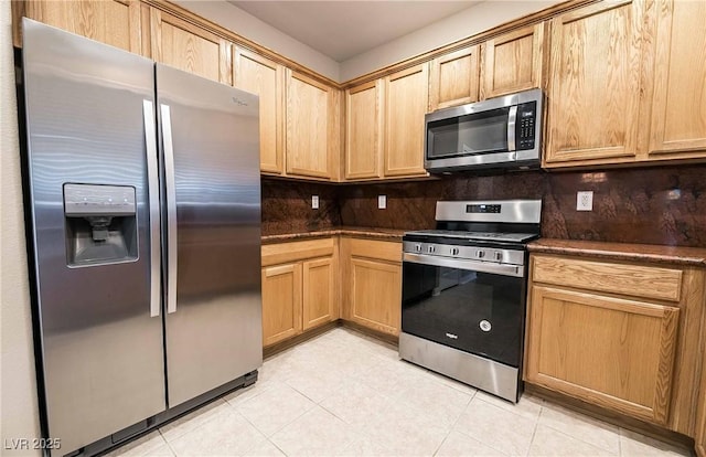 kitchen with light tile patterned floors, decorative backsplash, and appliances with stainless steel finishes