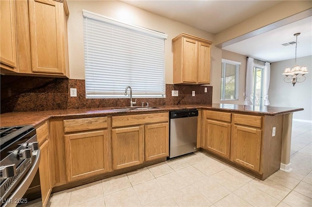 kitchen featuring appliances with stainless steel finishes, decorative light fixtures, sink, a notable chandelier, and kitchen peninsula