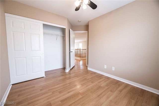 unfurnished bedroom with ceiling fan, light wood-type flooring, and a closet