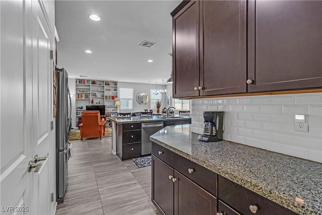 kitchen with light stone counters, dark brown cabinetry, and stainless steel appliances